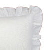 The corner of a white ruffle pillow with blush lining